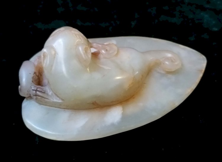 M001. A White Jade Pendant of a "Huan "Holding a Ganoderma and Lying on the Leaf